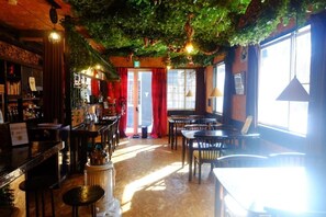 A bar area with a counter, stools, and a seating area with tables and chairs. - HAJIMARINOYADO D'LL (AGATSUMAGUN,TSUMAGOIMURA,)
