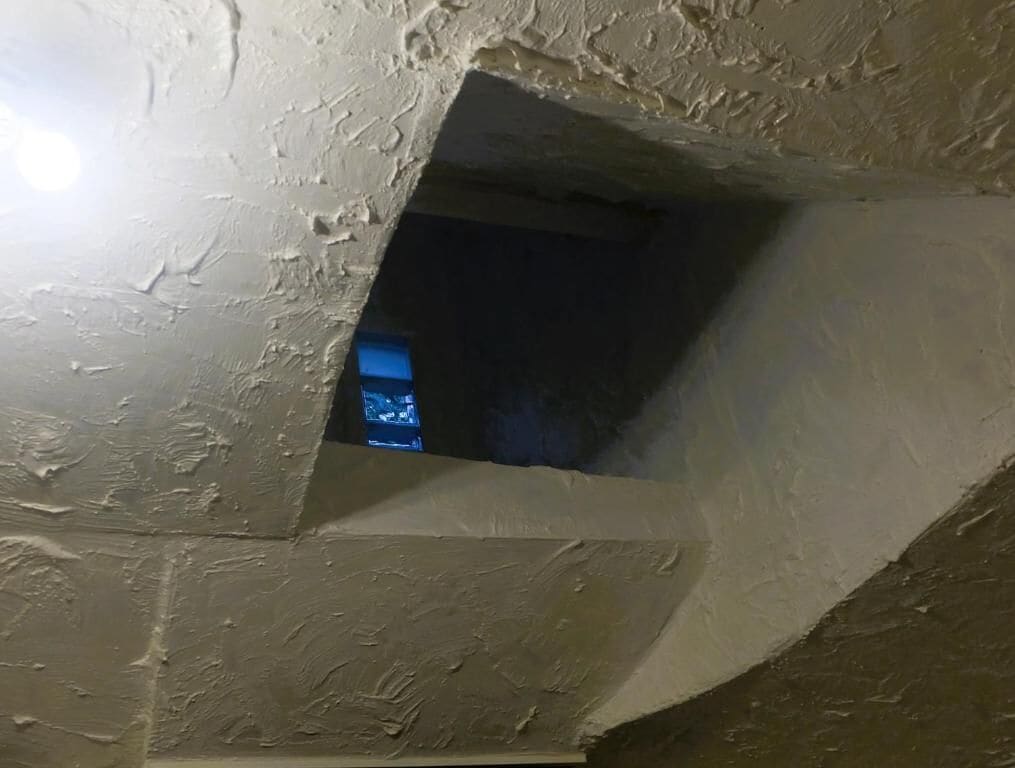 A room with a sloped ceiling and a small window.