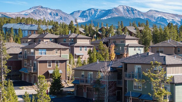 A residential area with multi-story buildings, a mountain backdrop, and a clear sky. - Timbers 9-4 New, spacious condo in Fraser, private deck and more! (Fraser)