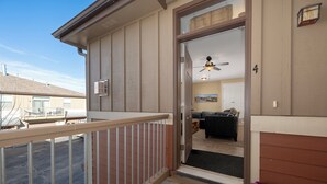 A residential entryway with a balcony, a welcome mat, and a door leading to a living room with a couch and a ceiling fan. - Timbers 9-4 New, spacious condo in Fraser, private deck and more! (Fraser)