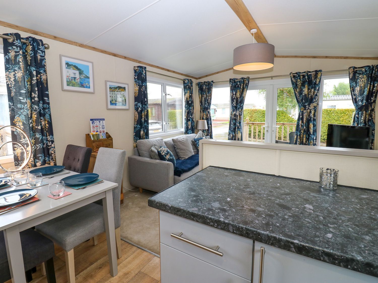 A cozy room with a dining table, a sofa, and a kitchen area with a countertop.
