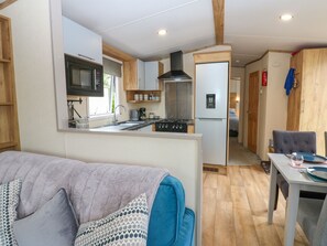 Una cocina compacta con microondas, estufa y refrigerador.