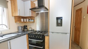 A compact kitchen with a gas stove, oven, and a refrigerator. - Plot 41 (Carlisle)