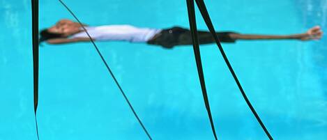Ein Schwimmbecken mit einer Person, die auf einem Schwimmreifen liegt.