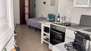 Una cocina compacta equipada con microondas, horno y cafetera.