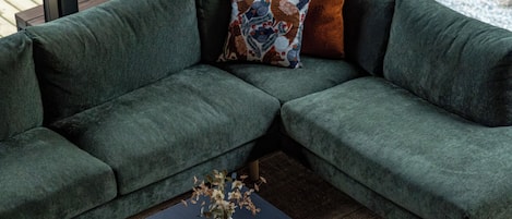 Un canapé modulable agrémenté d’un coussin décoratif et d’un vase posé sur une table basse.