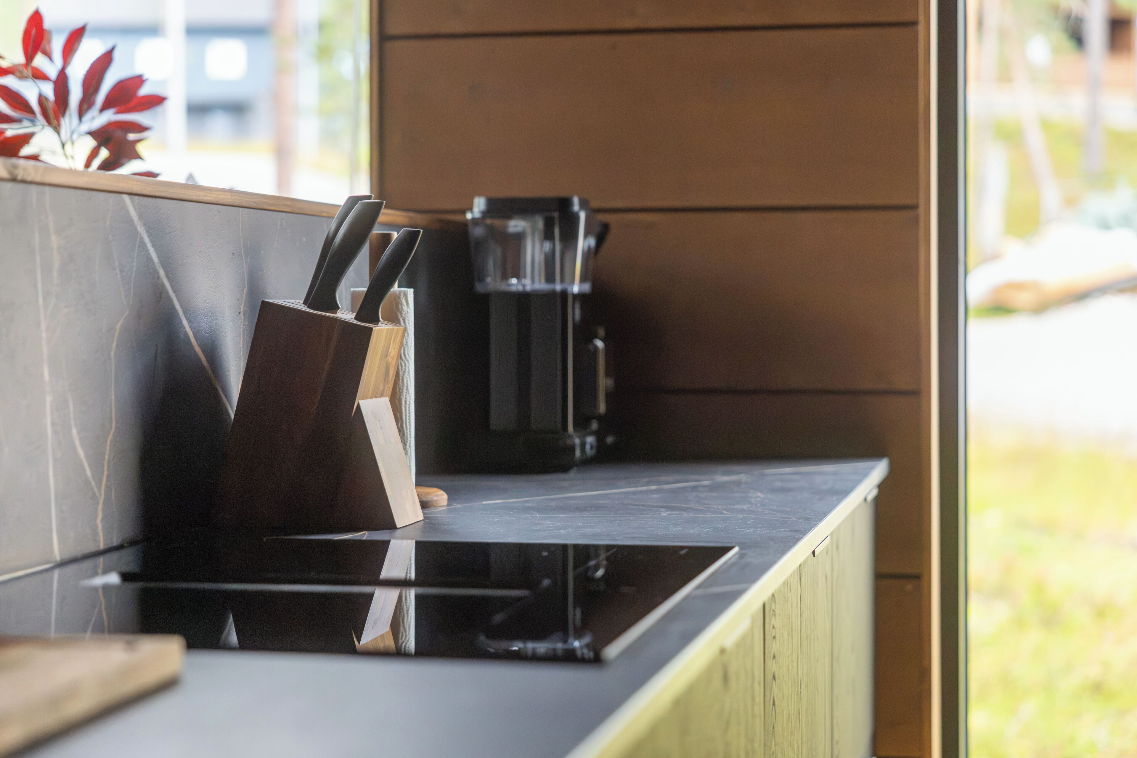 A kitchen counter with a knife block and a coffee machine.