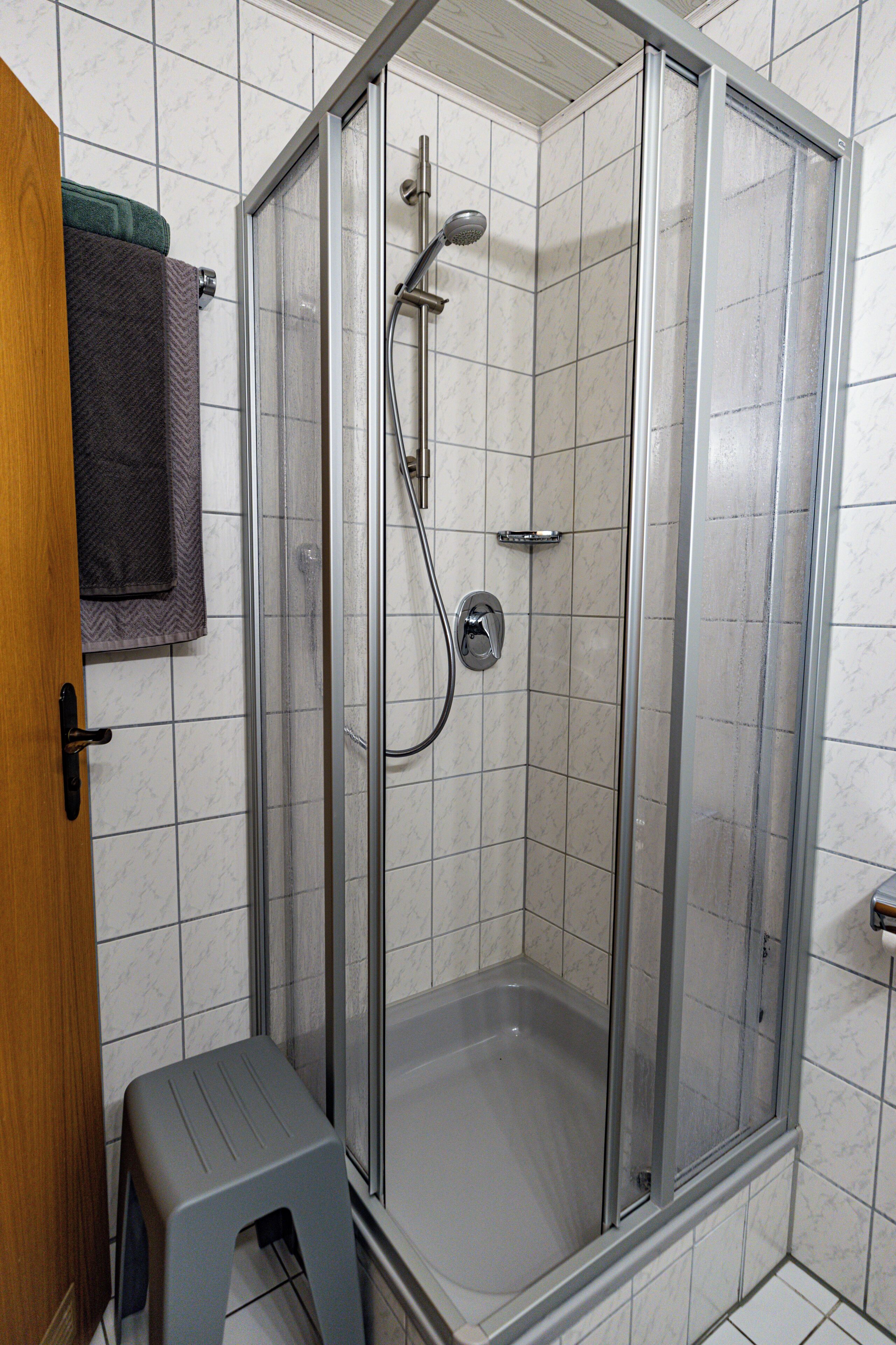 Een douche, een haardroger, handdoeken, toiletpapier