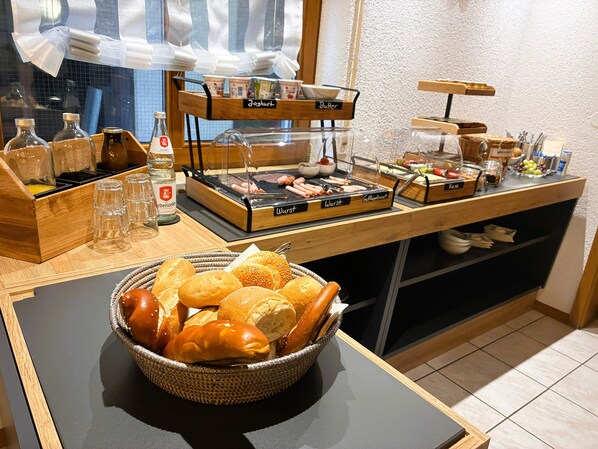 A buffet setup with various food items and condiments.