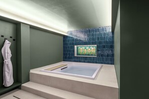 Un baño moderno con una bañera, un perchero para toallas y una obra de arte enmarcada en la pared.