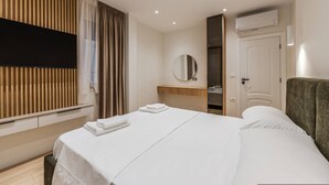 A hotel room with a bed, a TV, a mirror, and a wardrobe. - A H Azure Apartaments 1BR (Vlorë)