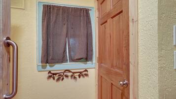 A wooden door with a window above it, a metal handle, and a wall-mounted decoration.