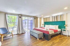 A bedroom with a bed, a chair, a bench, and a small table.