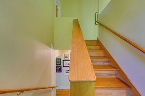 A wooden staircase with a handrail, light green walls, and framed pictures on the wall. - Waterfront Cottage! Family-friendly Hideaway (Round Pond)