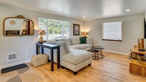 A living room with a sectional sofa, a small table, a side table, a mirror, and a fireplace. - Walk to Spanaway Lake: Chic Home w/ Rooftop Deck! (Spanaway)