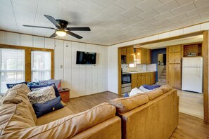 A living room with a sofa, a TV, and a ceiling fan. - 1 Mi to Marina! Family Lake of the Ozarks Home (Sunrise Beach)