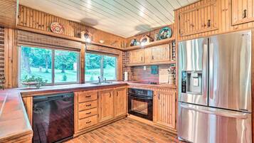 A kitchen with wooden cabinets, a stainless steel refrigerator, and a dishwasher.