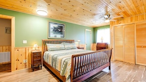 A wooden-paneled bedroom with a bed, a nightstand, a lamp, and a ceiling fan. - 2-home Country Estate Near Clayton! 2 Hot Tubs (Clayton)
