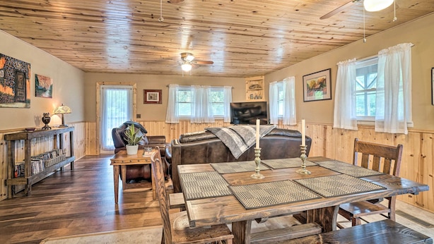 A cozy room with a wooden ceiling, a dining table with placemats, a leather sofa, and a bookshelf. - 2-home Country Estate Near Clayton! 2 Hot Tubs (Clayton)