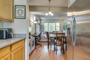 A kitchen with a refrigerator, coffee maker, and wooden cabinets.