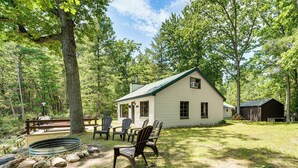 A cabin with a porch, outdoor seating, and a fire pit. - Angler Friendly! Pere Marquette Riverfront Retreat (Baldwin)
