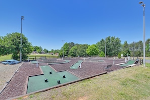 A miniature golf course with multiple holes, benches, and a picnic table. - Pool & Dock Access! Badin Lake Resort Gem (New London)