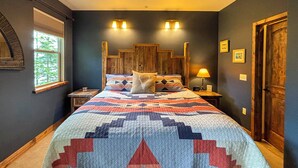 Un dormitorio con una cama grande, dos mesitas de noche, una ventana y una puerta.
