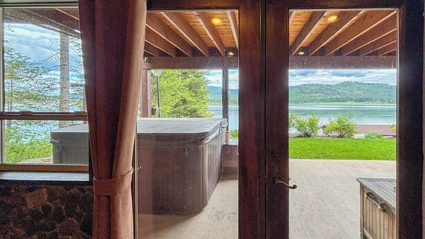Eine Holztür, die zu einem Zimmer mit Seeblick und Bergblick führt.