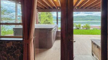 A wooden door leading to a room with a view of a lake and mountains.