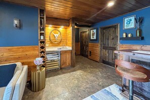 A bathroom with wooden walls, a sink, and a mirror.