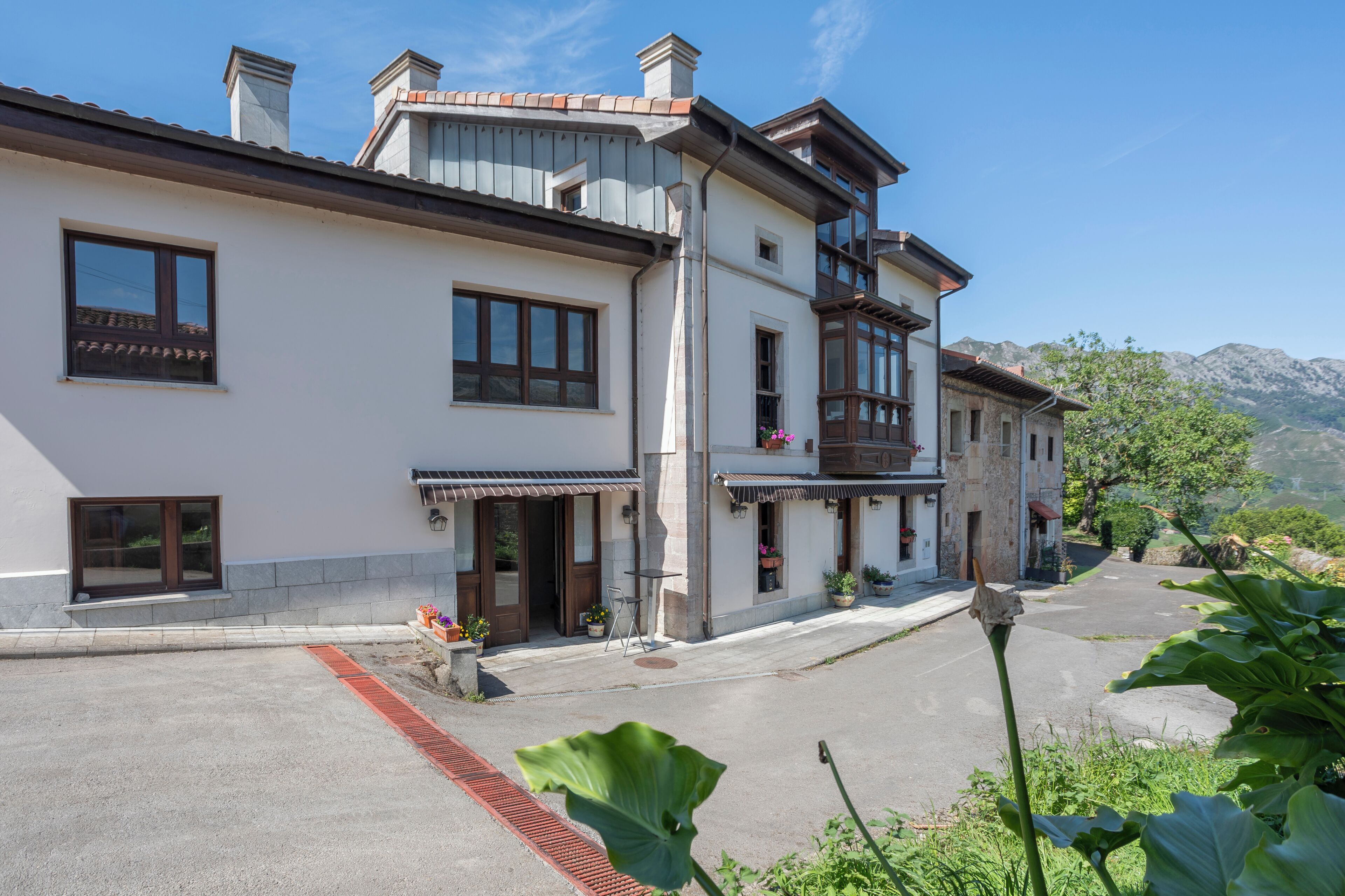 A two-story building with a balcony, a window, and a door.