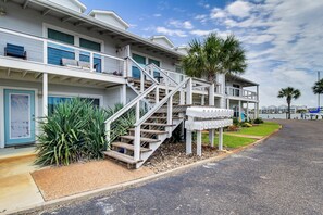 A beachfront hotel with multiple balconies, a staircase leading to the upper floors, and a mailbox. - 3BR Condo on the Bay w/ Pool and Perks (Rockport)