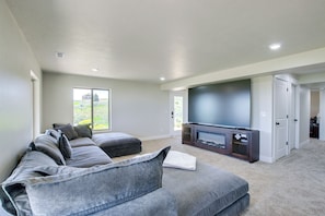 A modern living room with a sectional sofa, a flat-screen TV, and a fireplace.