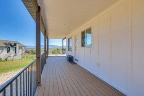A covered porch with a wooden deck, large windows, and a view of the landscape. - 2 Mi to Bear Lake! Group Getaway w/ Mountain Views (Garden City)