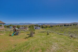 Ein Wohngebiet mit Spielplatz, Häusern und freiem Blick auf ferne Berge.