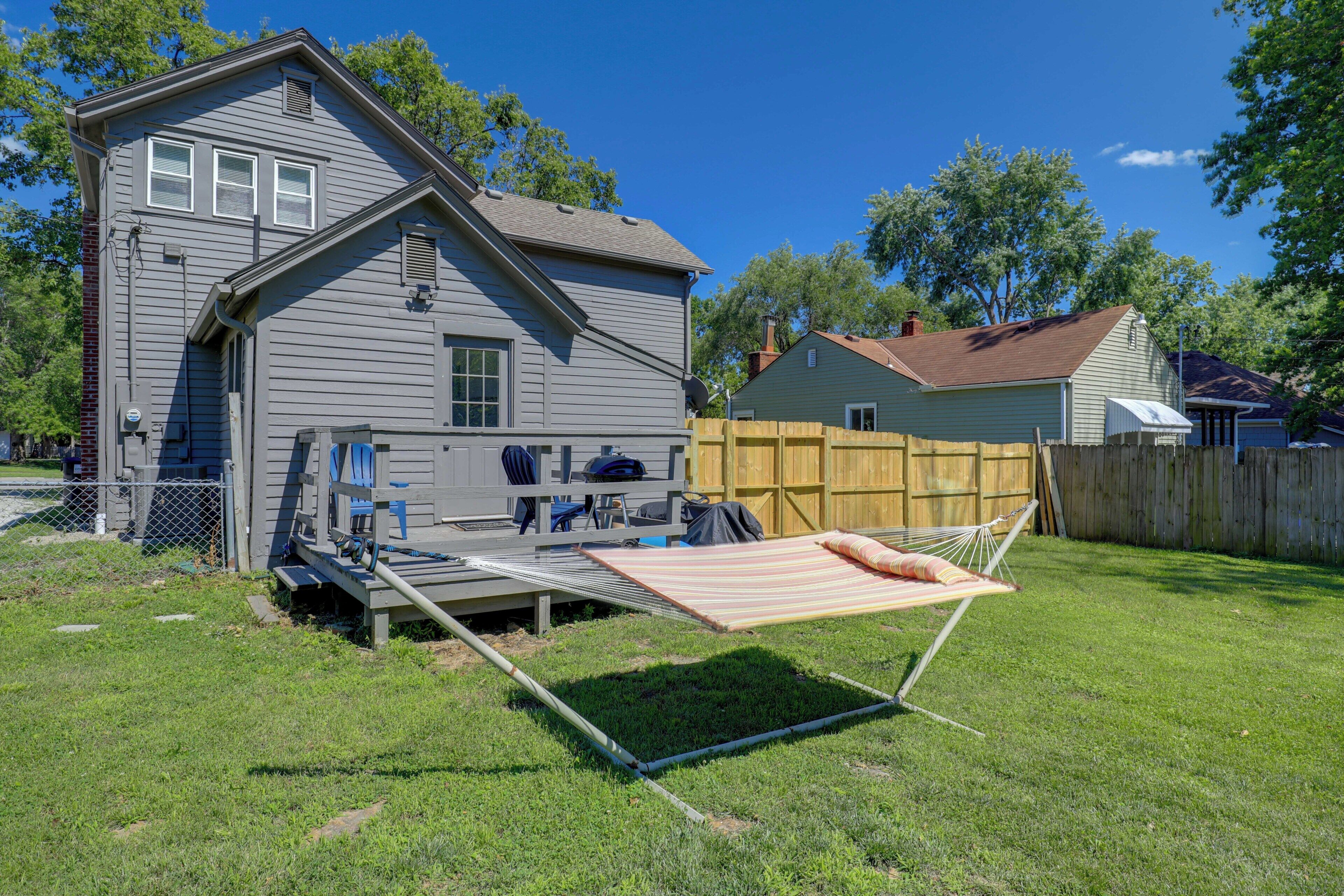 Una casa con patio trasero, un trampolín y una cerca de madera.
