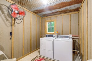 A laundry room with two stacked washers and dryers, a fan, and a window. - Creek Access & On-site Trails: Serene Ozark Cabin (Stella)