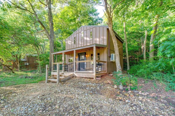A wooden cabin with a porch, surrounded by trees. - Ozark Escape! Cabin w/ On-site Hiking & Fishing (Stella)