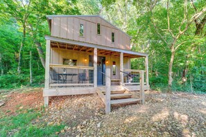 A wooden cabin with a porch, built into a forested area. - Ozark Escape! Cabin w/ On-site Hiking & Fishing (Stella)