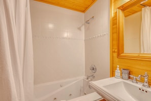 A bathroom with a bathtub, a sink, a showerhead, and a mirror. - Families w/ Pets! Riverfront Retreat in Grand Lake (Grand Lake)