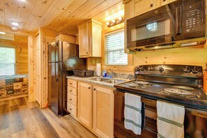 A modern kitchen with wooden cabinets, stainless steel appliances, and a granite countertop.