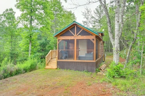 A cabin with a wooden exterior, large windows, and a covered porch. - Hunt & Fish Nearby! Peaceful & Remote Bostic Cabin (Bostic)