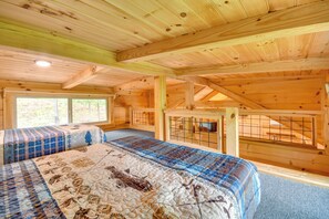 A wooden cabin interior with a bed, a window, and a fenced area. - Hunt & Fish Nearby! Peaceful & Remote Bostic Cabin (Bostic)