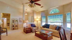 A spacious living room with a ceiling fan, a sofa, a coffee table, and a bookshelf. - 5 Mi to Sundial Bridge & River! Pet-friendly Haven (Redding)