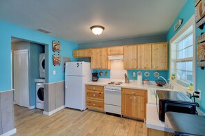 A kitchen with wooden cabinets, a washing machine, a stove, and a microwave. - 2-units w/ Private Boat Ramp! Rockport Escape (Rockport)