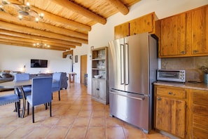 A modern kitchen with wooden cabinets, a stainless steel refrigerator, and a built-in oven. - Panoramic Mtn Views! Couple's Casita in Santa Fe (Santa Fe)