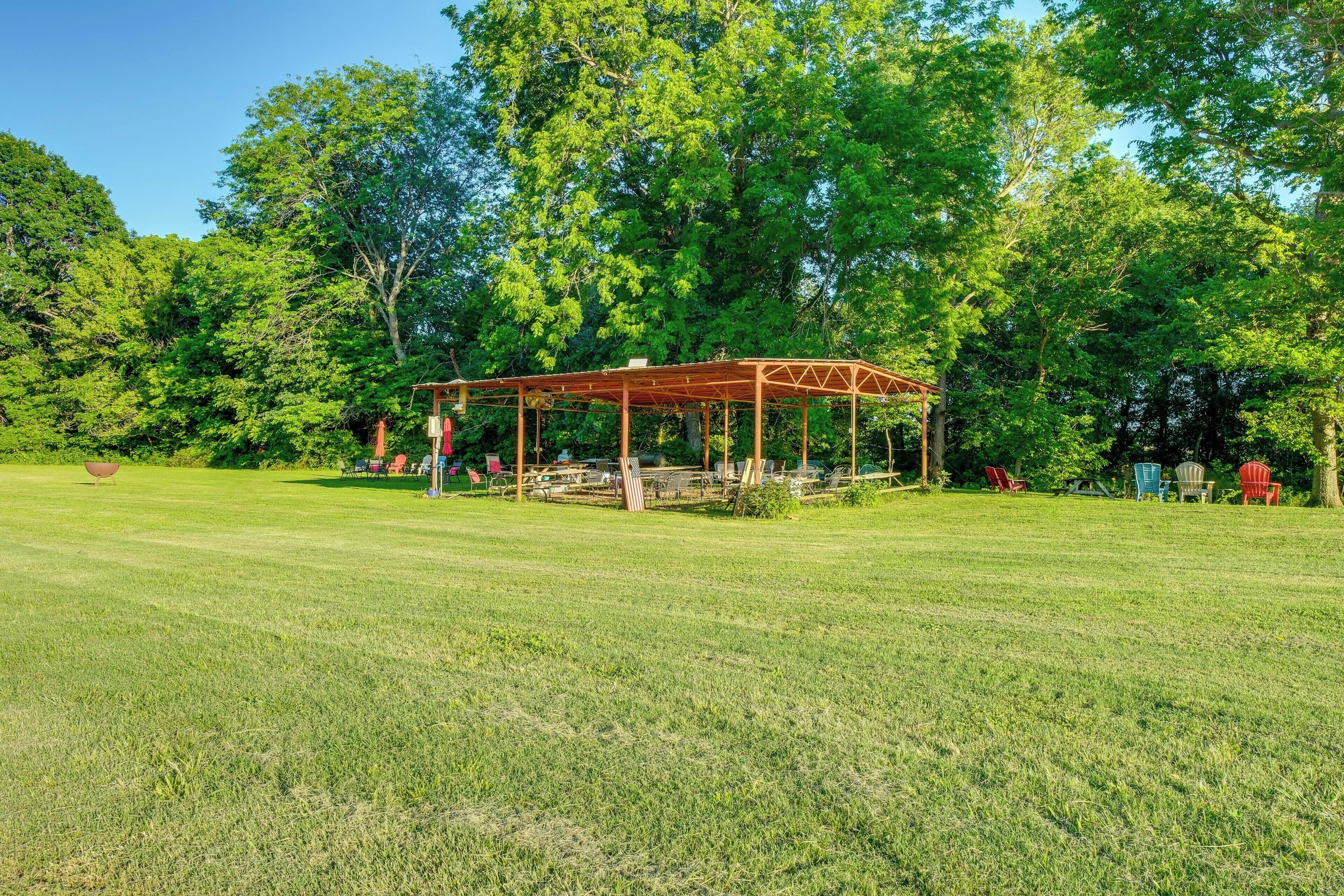 A gazebo in a grassy park with trees in the background.