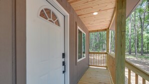 A wooden deck with a white door and windows, leading to a forested area. - Woodsy Cabot Escape in Arkansas Countryside! (Cabot)