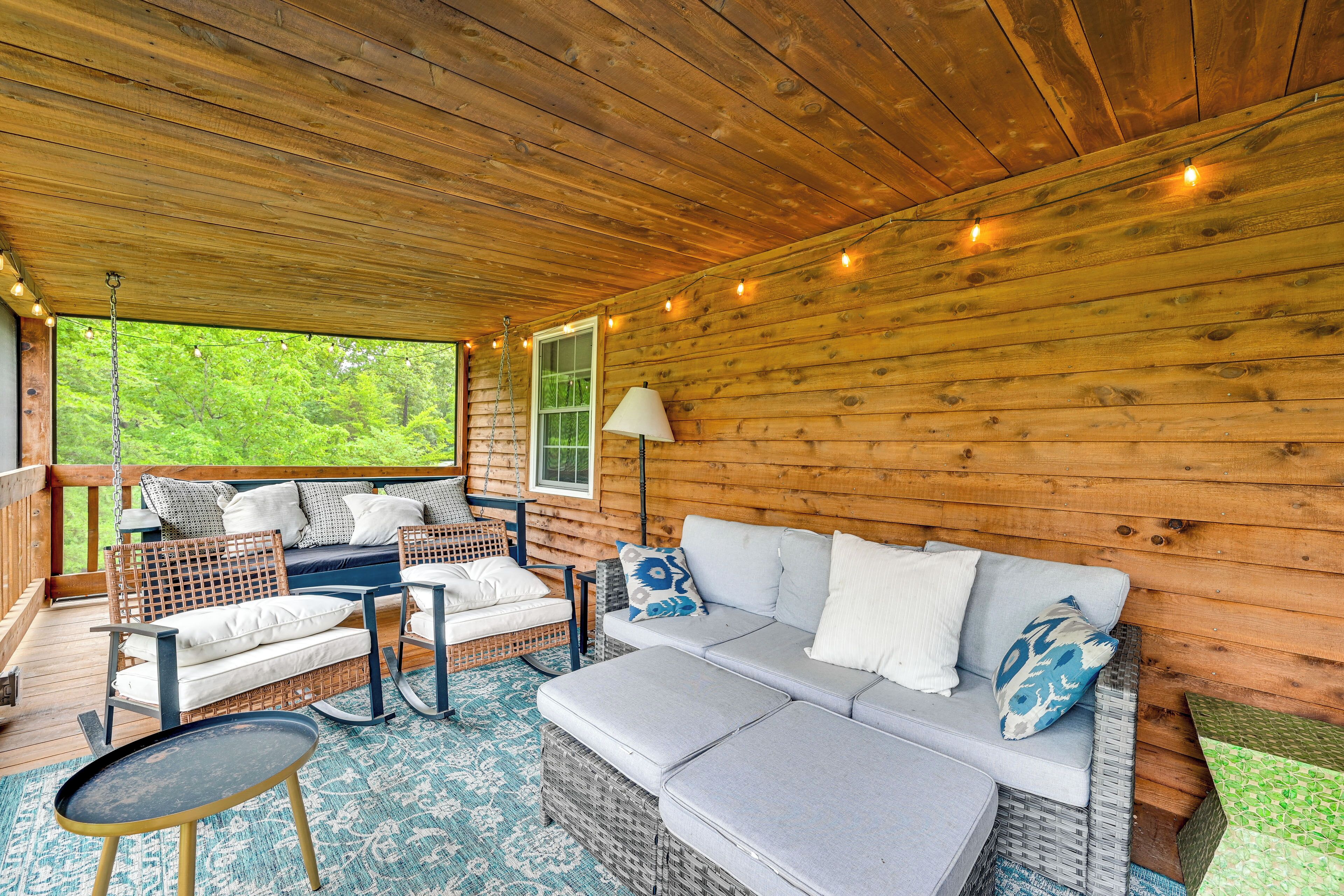 A wooden cabin interior with a sofa, chairs, and a table.