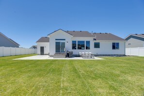 Ein modernes, zweistöckiges Haus mit Veranda, überdachter Terrasse und gepflegtem Rasen.